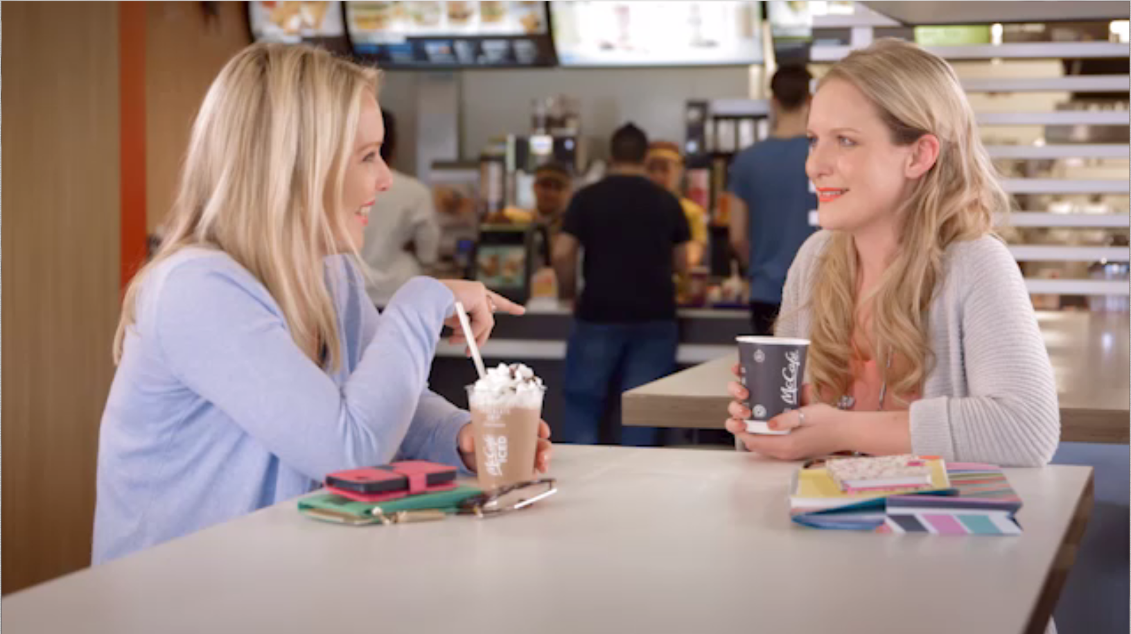 Two women chat over a McCafe drink